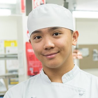 International student Deniel in chef outfit, at TAFE training kitchen facility