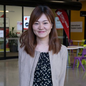 Student Sachiho smiles towards the camera. She stands in the foyer of North Metropolitan TAFE's Perth campus.