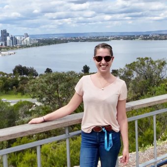Johanna stands with Perth city skyline and river in background