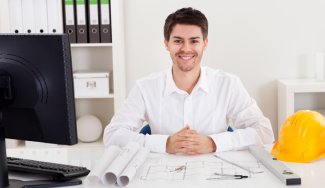 Person sitting at desk with designing papers