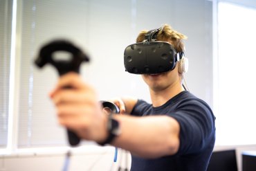 Student holding virtual reality equipment